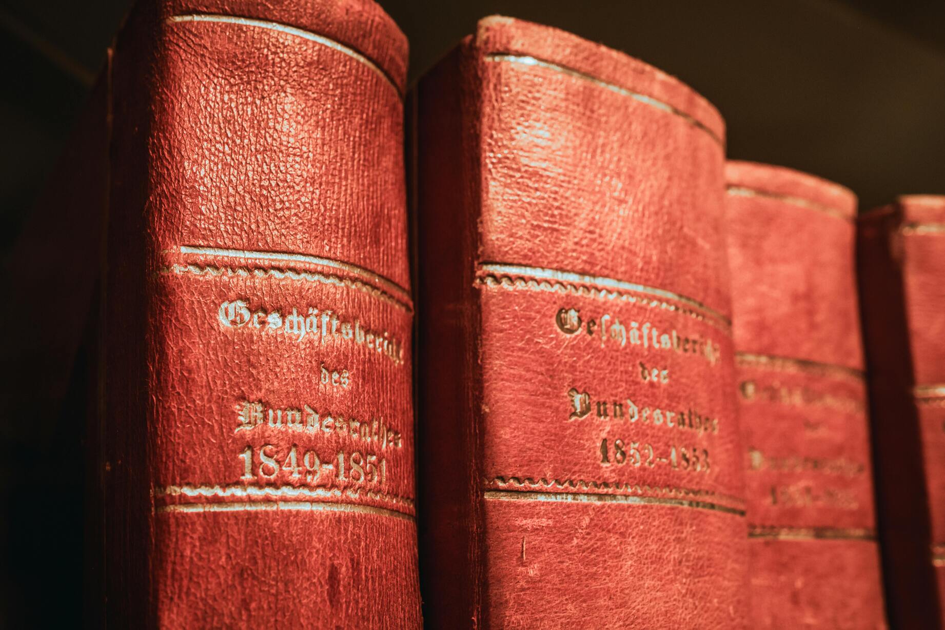 Editorial still-life of a single ledger binder on a Swiss office shelf, cloth texture dominant, mono spine label